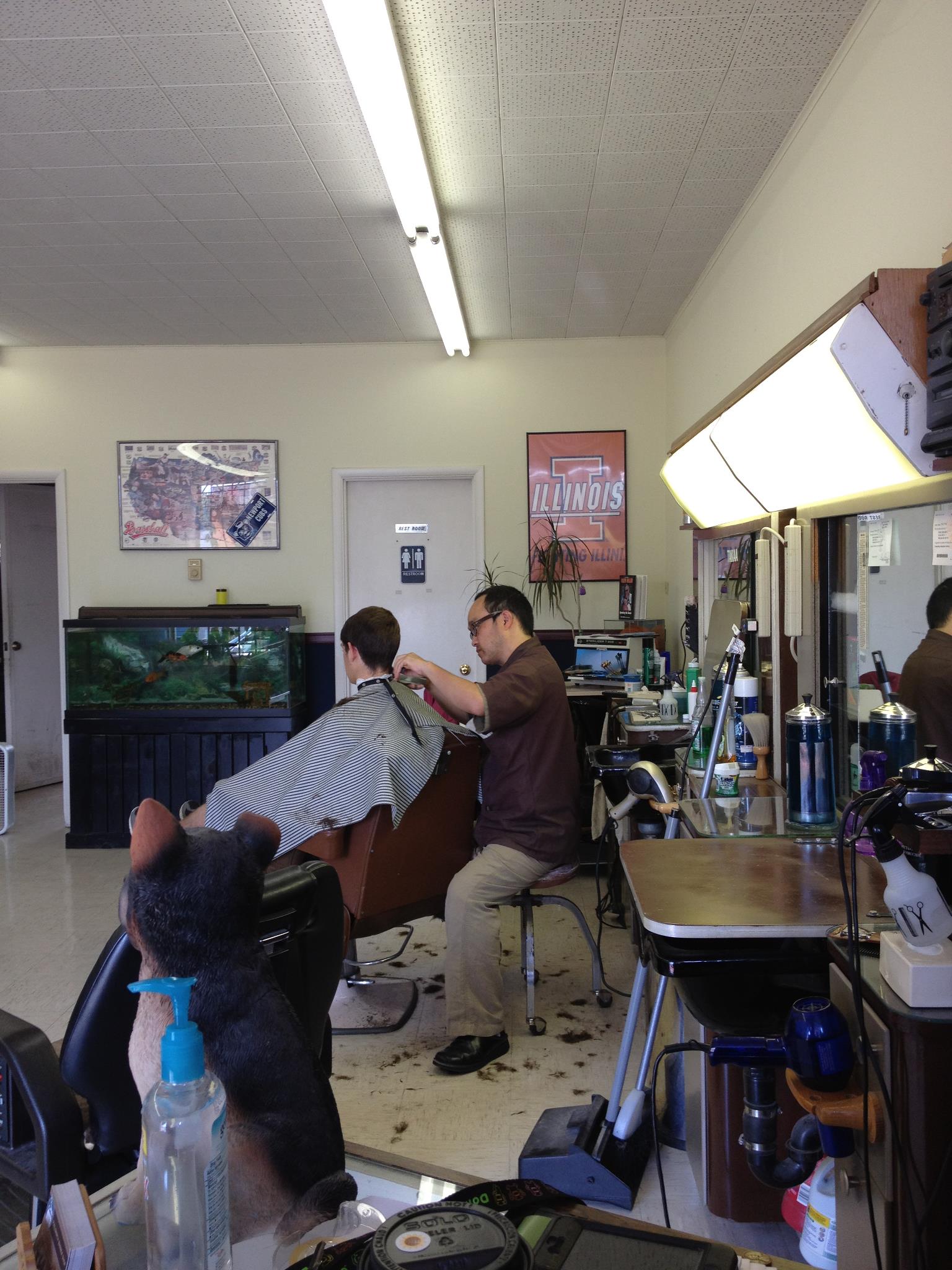 Archived public photograph of a haircut in progress inside the shop