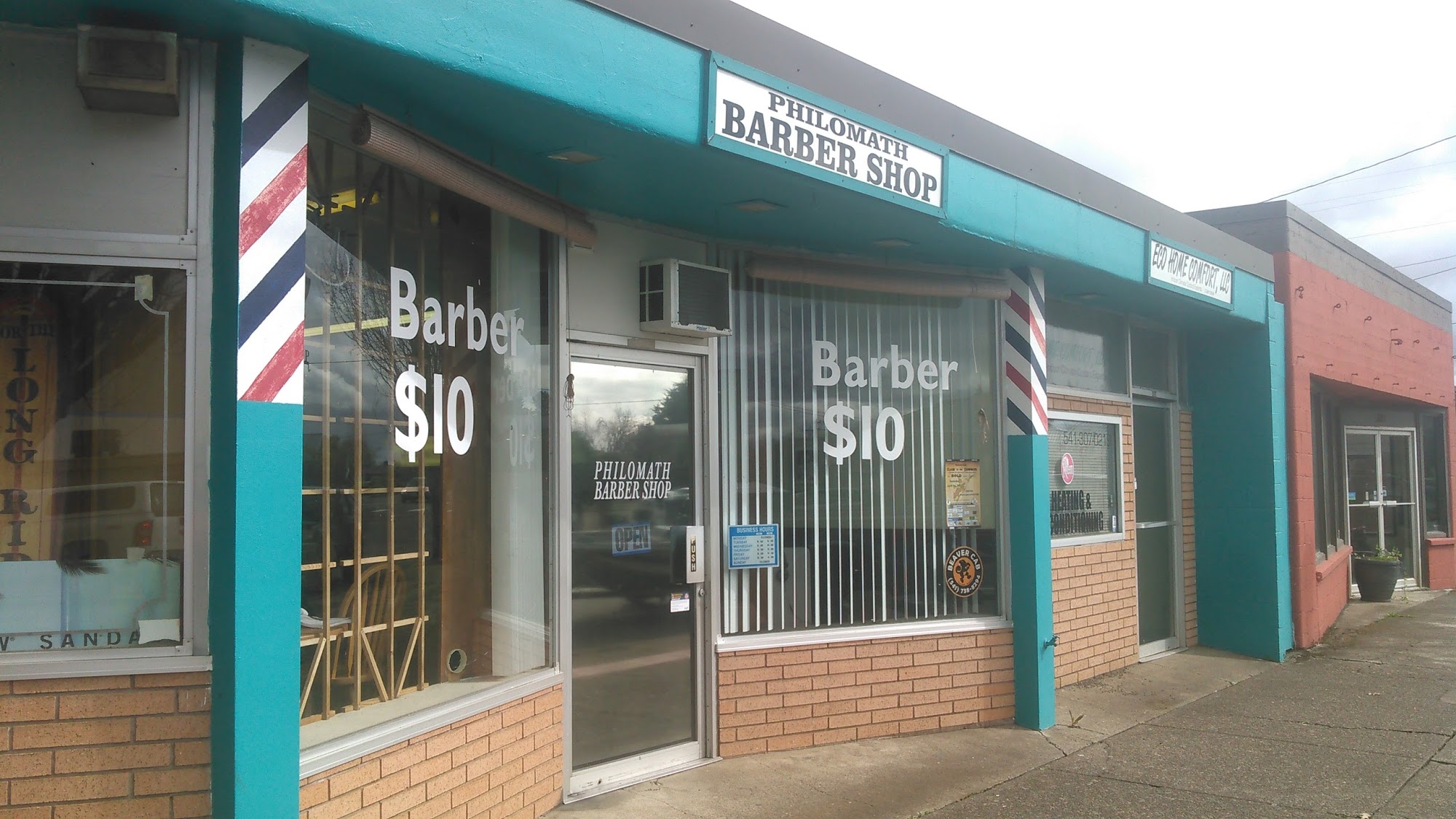Philomath Barber Shop storefront with its original sign and striped barber poles